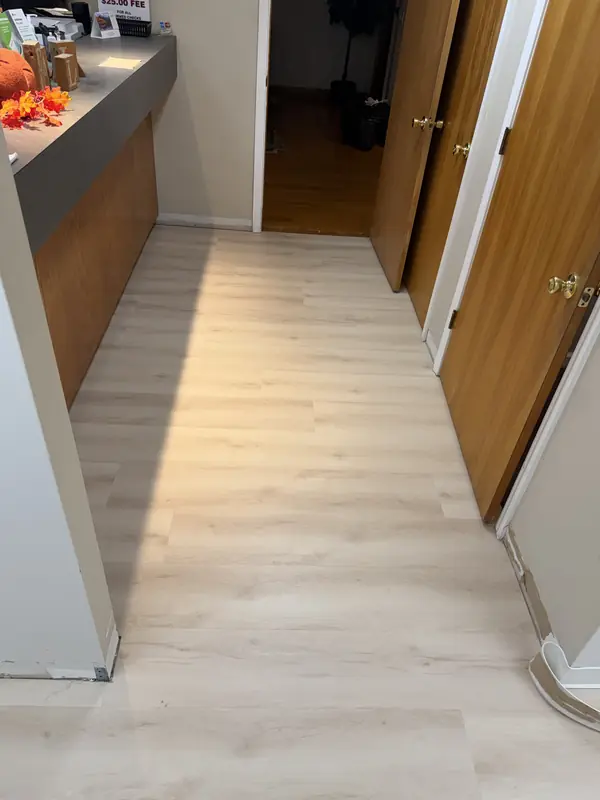 Commercial LVP flooring installed down an office hallway past the front counter