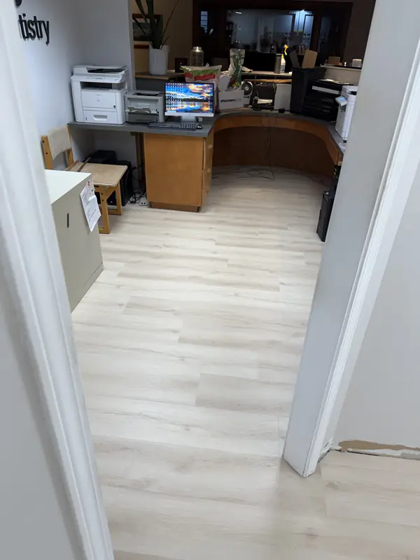 Light oak commercial LVP flooring in a dental office front desk and reception area